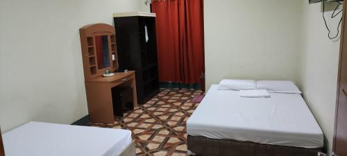 une petite chambre avec deux lits et un miroir dans l'établissement Feel Home Suites, à Pagadian