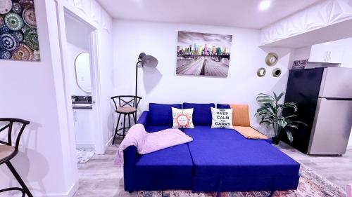 a blue couch in a room with a refrigerator at Modern Comfort Stay Near Airport in Edmonton