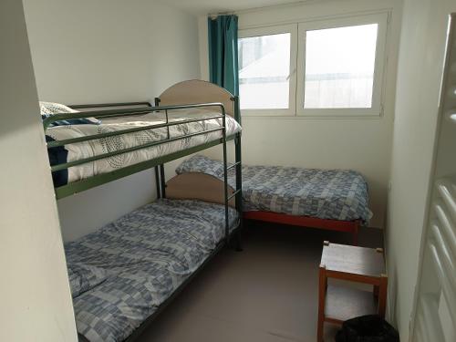 Dos literas en una habitación con ventana. en Arkenciel, en Mudaison
