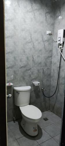 a bathroom with a toilet and a shower at Feel Home Suites in Pagadian