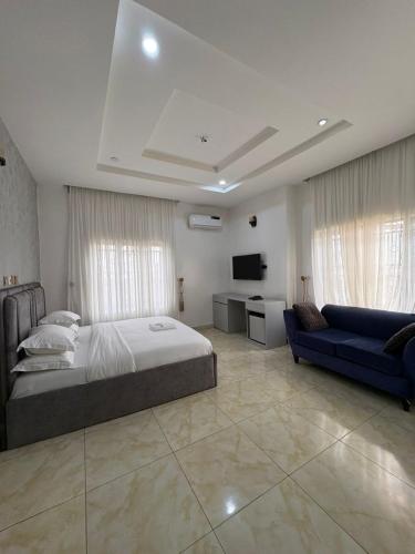 a large bedroom with a bed and a couch at Newcamp Hotel and Apartments in Abuja