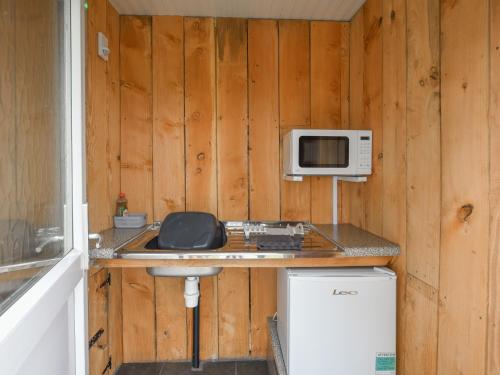 a kitchen with a counter with a microwave and a sink at The Sheep Pod - Uk50074 in Welshpool