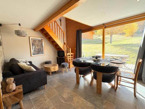 Chalet rénové, charme montagnard et confort moderne في لو ديفولي: غرفة معيشة بها طاولة وأريكة