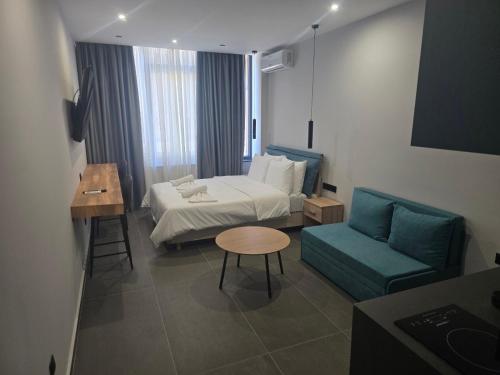 a hotel room with a bed and a blue couch at Timeless luxury suites & SPA in Thessaloniki