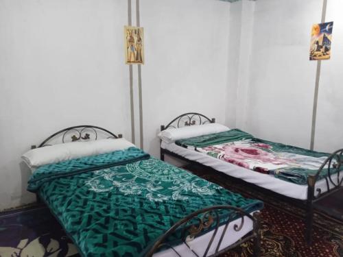deux lits côte à côte dans une pièce dans l'établissement Sun Rise House Luxor, à Al Aqālitah