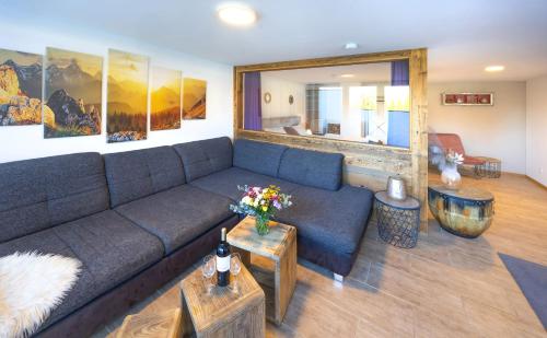Una sala de estar con un sofá azul y una mesa. en GM-Stays Wendelstein Lodge, en Fischbachau