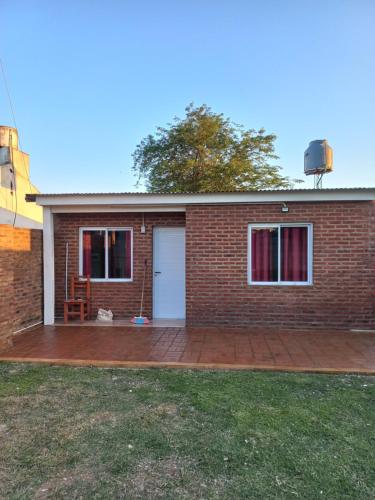 a brick house with a patio in front of it at Hospedaje la querencia in San Antonio de Areco