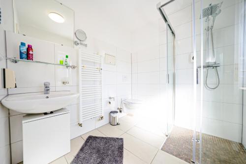 a white bathroom with a sink and a shower at Hotel Bären in Hechingen