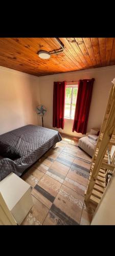 a bedroom with a bed and a wooden ceiling at Hospedaje la querencia in San Antonio de Areco