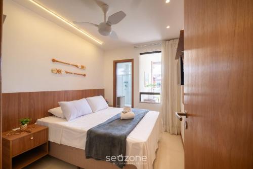 1 dormitorio con 1 cama con sábanas blancas y puerta en Condominio con Piscina a 450m de la Playa en Itacimirim - VBRs, en Pojuquinhos