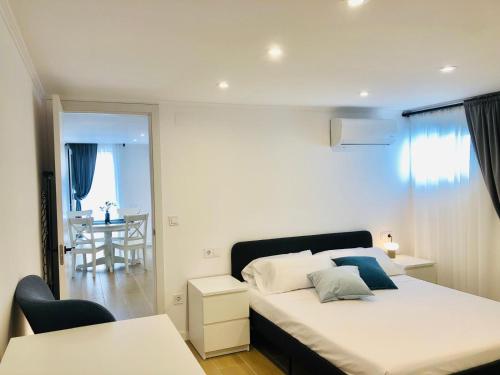a bedroom with a bed and a dining room at 101 - Beachside Renovated 1BR apt w private garden in Cambrils
