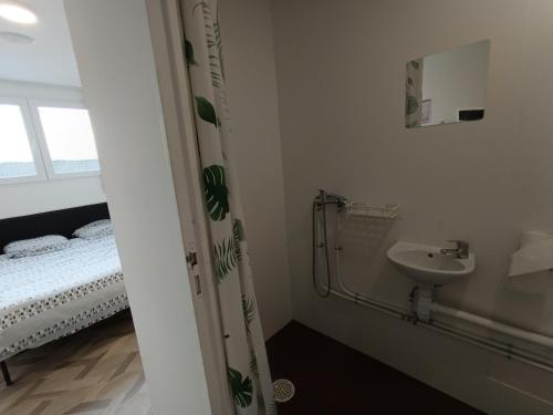 a bathroom with a shower and a sink and a bed at Campus Arkenciel - Montpellier Est in Mudaison