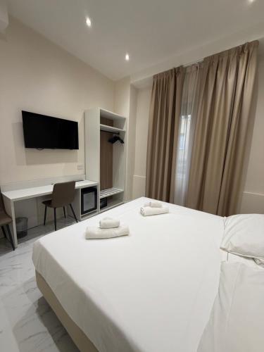 a bedroom with a large white bed and a desk at Hotel Margot in Milan
