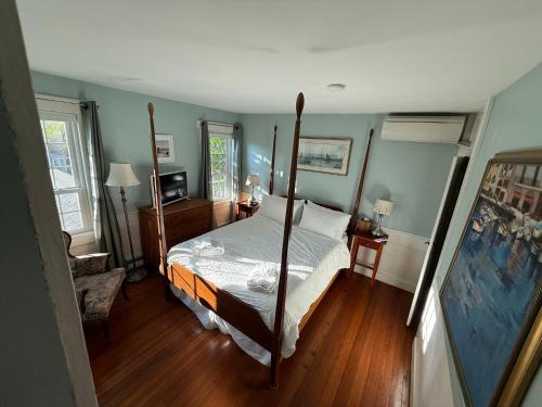 a bedroom with a four poster bed and blue walls at The Copper Swan in Wellfleet