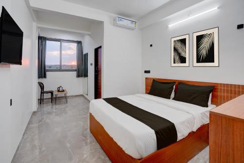 a bedroom with a large bed and a television at Collection O Kanifnath Trek Pune in Jadhavwadi