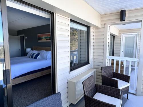 a room with a bed and a balcony with a bedroom at Lake Views Close to Weirs in Cedar Lodge Complex in Laconia