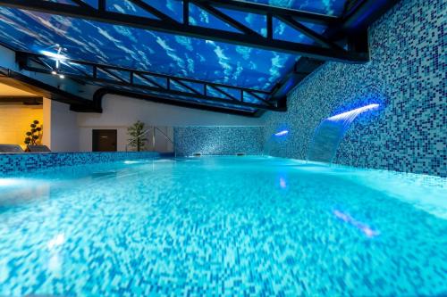 an indoor swimming pool with a blue ceiling at Tomy Forest Cigar Bar in Ocka Gora