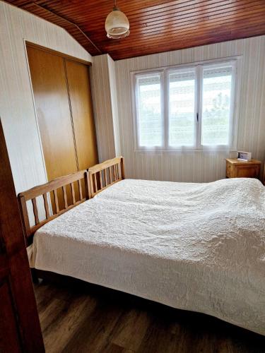 ein Schlafzimmer mit einem weißen Bett und einem Fenster in der Unterkunft La Colline d'Estaing, Maison 4 pers avec terrasse in Le Nayrac