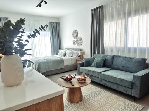 a living room with a blue couch and a bed at Grace Living Studio 201 in Limassol