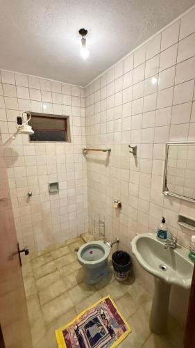 a bathroom with a toilet and a sink at Pousada cosmo in Uberaba