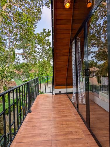 a wooden walkway leading to a house at Shenu Villa in Talpe