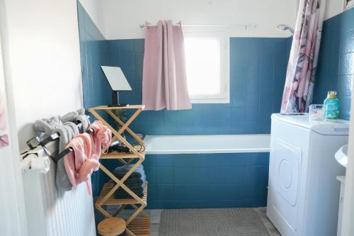a bathroom with blue walls and a bath tub at Cocon en bois Majeur - 4 couchages au cœur de Limoux in Limoux
