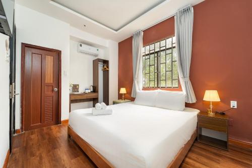a bedroom with a large white bed and a window at KAS Luxury Hotel in Ho Chi Minh City