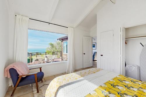 een slaapkamer met een bed en een groot raam bij Perched on the Bluff - Casita in Mendocino