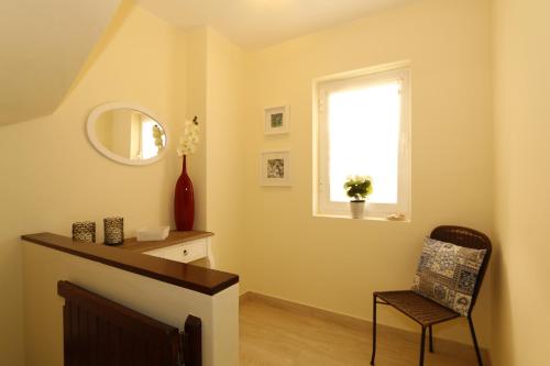 Una sala de estar con una silla y una ventana. en The Old Village, Prestige and Solar by Village 4U, en Vilamoura