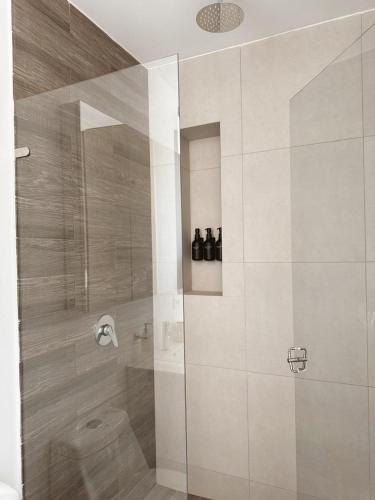 a bathroom with a shower with a glass door at KOA Villeta - Loft y terraza con vista a la montaña in Nimaima