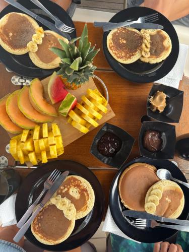 a table topped with plates of pancakes and fruit at Boat - Yoga and sailing retreat in Marigot