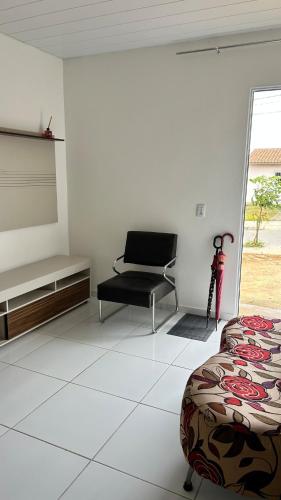 ein Zimmer mit einem Bett und einem Stuhl darin in der Unterkunft Casa para o Natal in Garanhuns