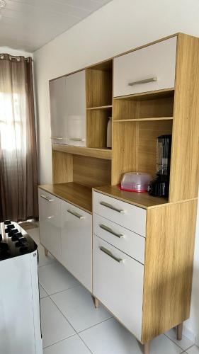 eine große Küche mit weißen Schränken und Holzregalen in der Unterkunft Casa para o Natal in Garanhuns