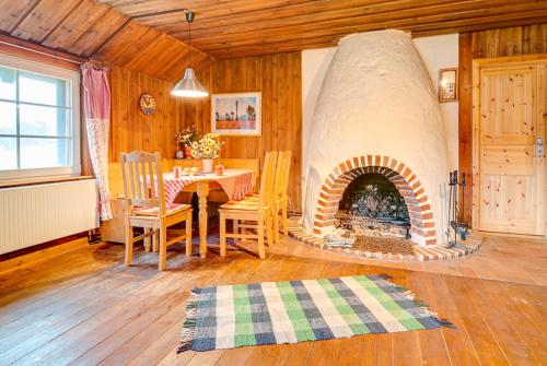 a dining room with a fireplace in a room with a table at Bungalow Prütz in Fleeth