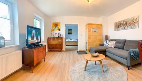 a living room with a couch and a tv at FeWo Feldblick in Rutenberg