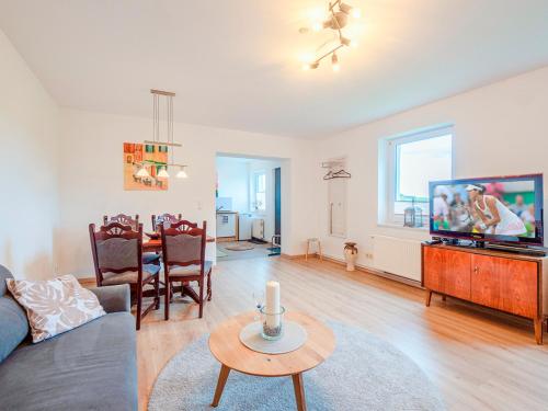 a living room with a couch and a tv and a table at FeWo Feldblick in Rutenberg
