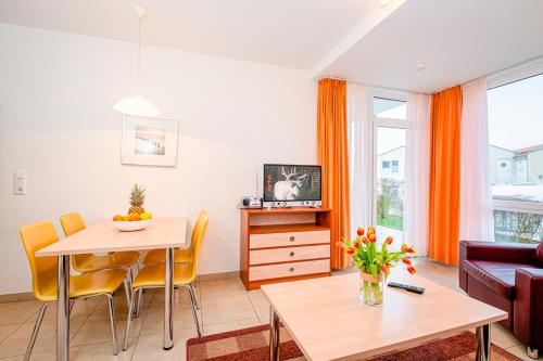 a living room with a table and a couch at Residenz Meeresblick D Fewo E5 in Rerik