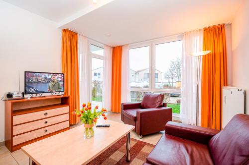 a living room with a couch and a tv at Residenz Meeresblick D Fewo E5 in Rerik