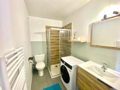 a white bathroom with a sink and a toilet at Bel appartement avec place de parking privative in Aix-les-Bains