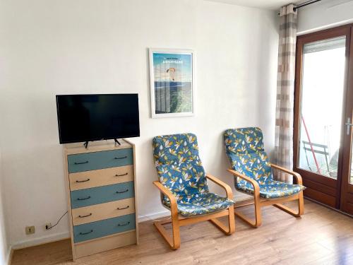 a living room with two chairs and a television at Bel appartement avec place de parking privative in Aix-les-Bains