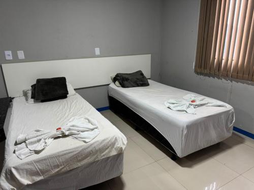two beds in a room with towels on them at Brasil hotel in Canaã dos Carajás