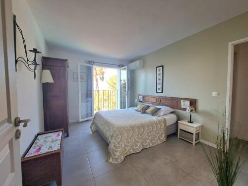 een slaapkamer met een bed en een groot raam bij Villa K Presqu ile de Giens in Hyères