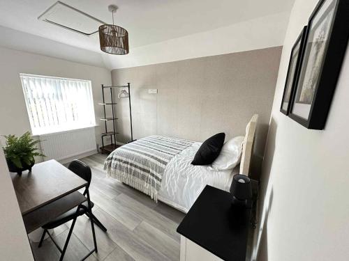 a bedroom with a bed and a desk and a table sidx sidx sidx at Contractor & Leisure Stay 4BR all en-suite and Parking in Portsmouth