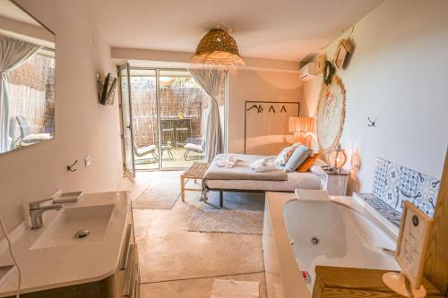 a bathroom with a tub and a bed in a room at Les Suites in Santa María de Palautordera