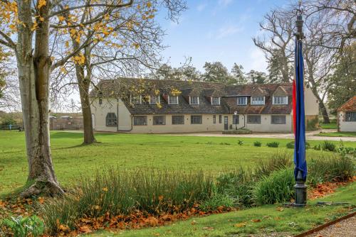a flag on a pole in a field in front of a house at Priory Coach House in Pagham