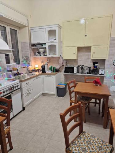 a kitchen with white cabinets and a table and chairs at Althea Etna Garden in Nicolosi