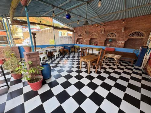 Cette chambre dispose d'un sol en damier, de tables et de chaises. dans l'établissement Geel Heritage - A Restored Haveli, à Jodhpur