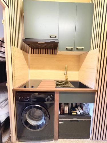 a kitchen with a sink and a washing machine at Studio familial, chaleureux, pied des pistes, 5e étage, côté calme in Superdevoluy