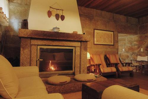 a living room with a fire in a fireplace at Casa da Alvarinha. Privacidade, Conforto, Natureza in Paredes