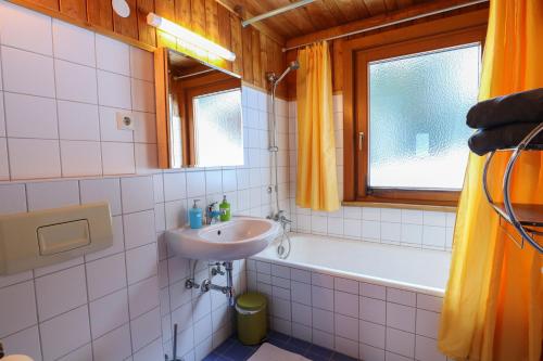 a bathroom with a sink and a bath tub at Ferienbungalows MOHR in Sankt Jakob in Defereggen